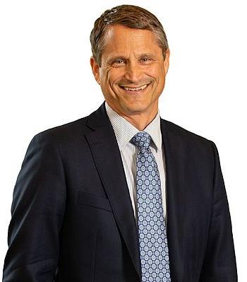 Headshot photo of Alex Bryan smiling against a white background